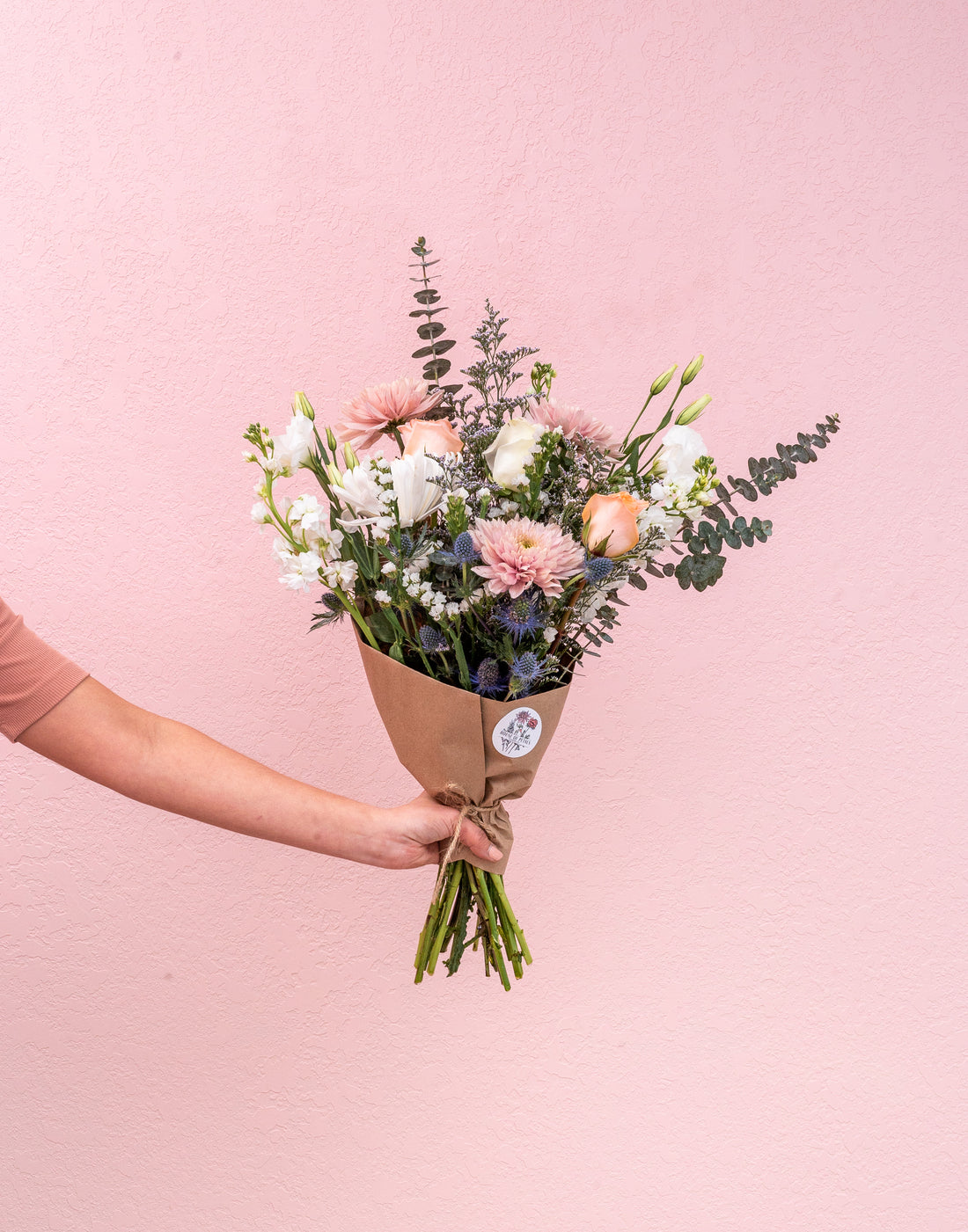 Our grand arrangement is full and luxurious and includes 20-25 stems. Choose a wrapped option with our custom sticker or a vase.